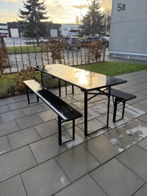 Svart utomhusbord med bänkar, perfekt för utemiljöer.
