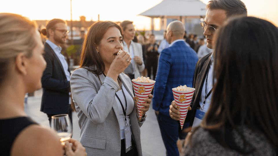 Folk på ett event som äter från popcornstrutar